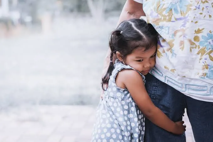 A distressed, clingy child holding tightly to a caregiver.