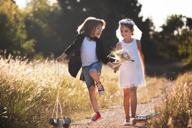 Two children role-playing a wedding or married couple during pretend play.