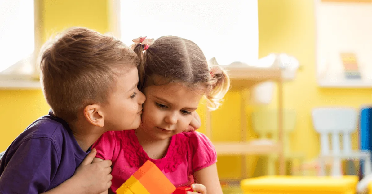 Two young children showing affection while playing together.