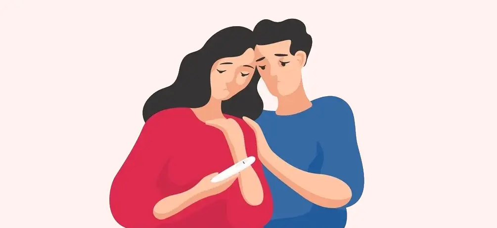 A couple looking somber while holding a negative pregnancy test.