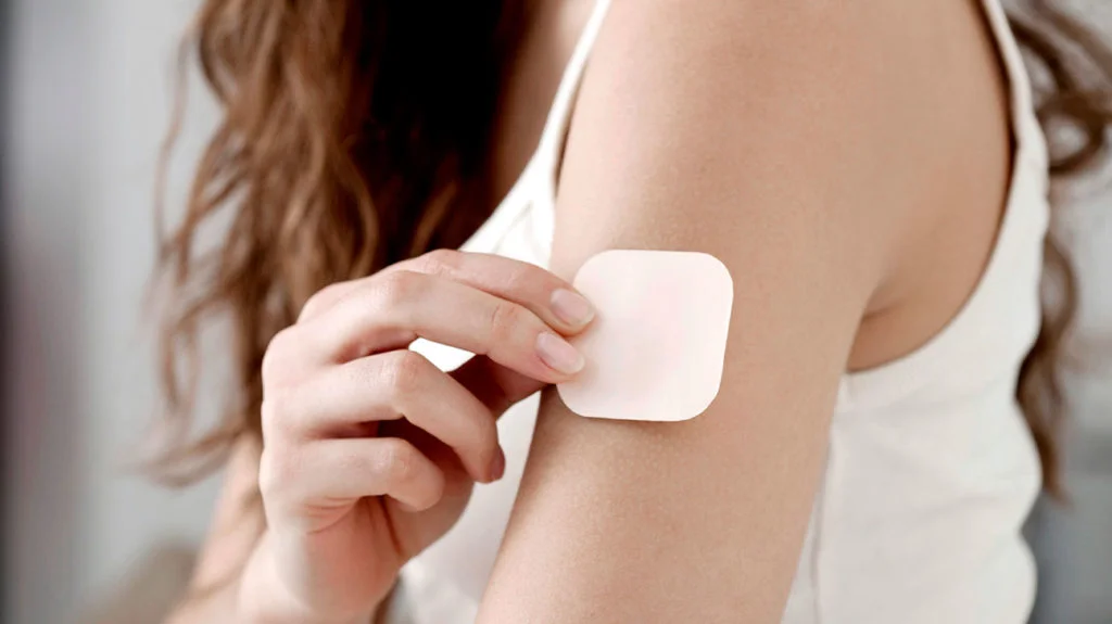 A contraceptive patch applied to the upper arm.