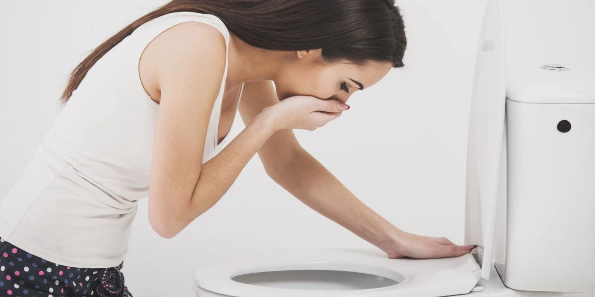A pregnant person experiencing nausea, representing morning sickness in early pregnancy.